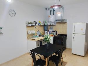 a kitchen with a black table and a white refrigerator at Nido del Sol in Pocito