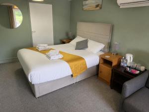 a bedroom with a large bed with a chair and a bed sidx sidx at Kings Arms in Llandysul
