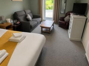 a bedroom with a bed and a living room with a couch at Kings Arms in Llandysul