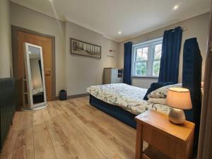 a bedroom with a bed with blue curtains and a table at 1 Bed in Duns oc-83140 in Duns