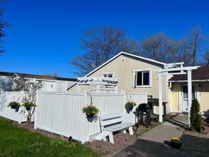 a white fence in front of a house at Auberge Eldo Inn in Blind River