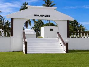 a white building with a gate and stairs at Vunakavika House - Village Stay in Nadi
