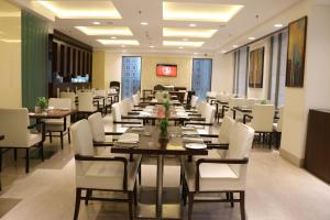 a large dining room with tables and white chairs at Country Inn & Suites by Radisson, Bhiwadi in Bhiwadi