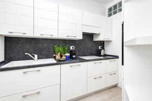 a white kitchen with white cabinets and a sink at 2 passi dal lago, Como Lake in Abbadia Lariana