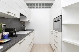 a kitchen with white cabinets and a black counter top at 2 passi dal lago, Como Lake in Abbadia Lariana