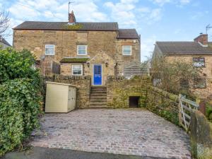 a brick house with a garage in front of it at 2 Bed in Belper oc-74965 in Crich