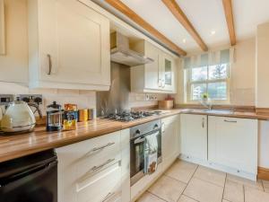 a kitchen with white cabinets and a stove top oven at 2 Bed in Belper oc-74965 in Crich