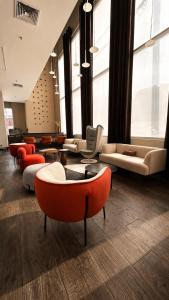 a lobby with couches and chairs and windows at Sol de Oro Hotel & Suites in Lima