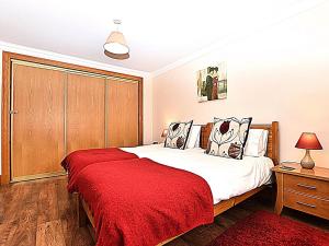 a bedroom with a bed with a red blanket at 2 Bed in Perth oc-86059 in Forgandenny