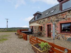 a stone house with a patio and a grill at 2 Bed in Perth oc-86059 in Forgandenny