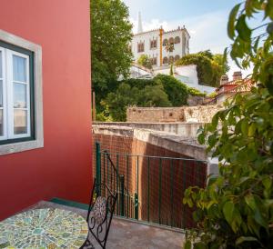 a balcony with a table and a view of a building at Santos da Vila in Sintra