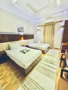 a hotel room with two beds and two rugs at Sunshine Pyramids Hotel & Restaurant in Cairo