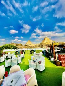 a restaurant with white chairs and tables on the grass at Sunshine Pyramids Hotel & Restaurant in Cairo