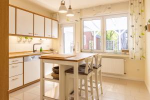 a kitchen with white cabinets and a table and chairs at Lieblingsplatz in Lathen
