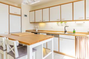a kitchen with white cabinets and a wooden table at Lieblingsplatz in Lathen