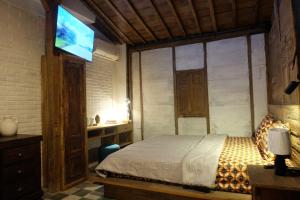 a bedroom with a bed and a flat screen tv at Jagadhita Villas in Sekatonan
