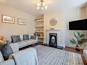 a living room with a couch and a fireplace at 3 Bed in Brockenhurst oc-nfl92 in Brockenhurst