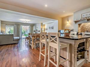 a kitchen and living room with a bar with stools at 3 Bed in Brockenhurst oc-nfl92 in Brockenhurst