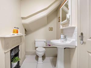 a white bathroom with a toilet and a sink at 3 Bed in Brockenhurst oc-nfl92 in Brockenhurst +14 photos