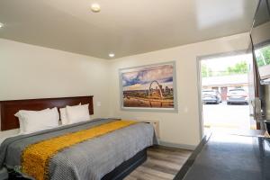 a bedroom with a bed and a painting on the wall at Indian Mound Motel in Fairmont City