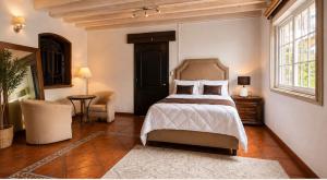 a bedroom with a bed and a chair and a window at Suite Copal in Tecozautla