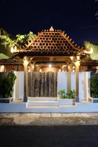 a gazebo with a tiled roof at night at Jagadhita Villas in Sekatonan +22 photos
