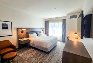 a hotel room with a bed and a chair at Courtyard by Marriott Eugene Downtown in Eugene