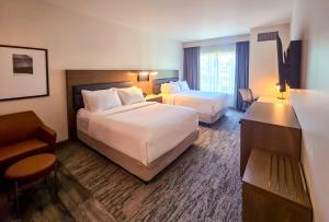 a hotel room with two beds and a chair at Courtyard by Marriott Eugene Downtown in Eugene +54 photos