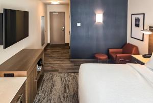a hotel room with a bed and a chair at Courtyard by Marriott Eugene Downtown in Eugene