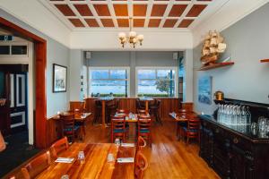 a restaurant with wooden tables and chairs and windows at The Pier Hotel in Kaikoura