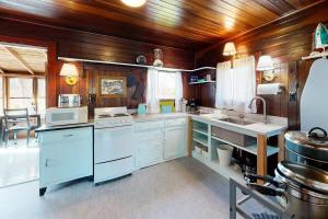 a large kitchen with white appliances and wooden walls at The Pinkletink in Oak Bluffs