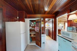 a kitchen with a white refrigerator and wooden walls at The Pinkletink in Oak Bluffs