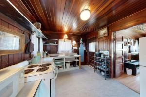 a large kitchen with wooden walls and wooden ceiling at The Pinkletink in Oak Bluffs +14 photos