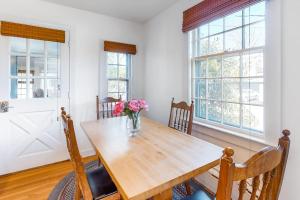a dining room table with a vase of flowers on it at Edgartown Cozy Corner in Edgartown