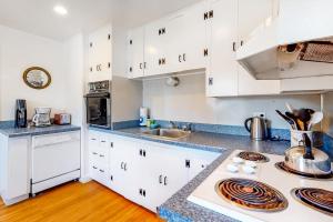 a kitchen with white cabinets and a counter top at Edgartown Cozy Corner in Edgartown +27 photos