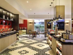 a large kitchen with a dining area and a table at Ibis Melaka in Malacca