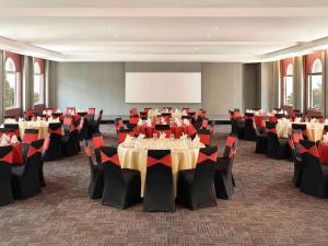 a conference room with tables and chairs and a screen at Ibis Melaka in Malacca +62 photos