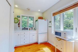 a kitchen with white cabinets and a refrigerator at Nana's Rear Treehouse in West Tisbury