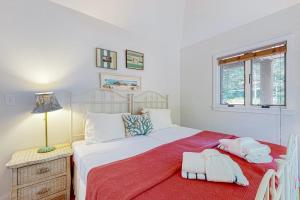 a bedroom with a large bed with a red blanket at Nana's Rear Treehouse in West Tisbury