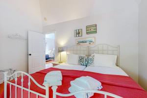 a bedroom with a large white bed with a red blanket at Nana's Rear Treehouse in West Tisbury +4 photos