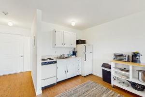 a kitchen with white cabinets and a white refrigerator at Large Studio with Patio and Pool in North Truro