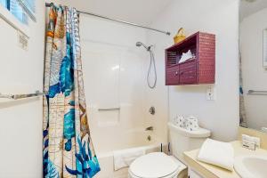 a white bathroom with a toilet and a sink at Large Studio with Patio and Pool in North Truro +6 photos