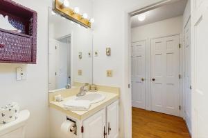 a white bathroom with a sink and a mirror at Large Studio with Patio and Pool in North Truro