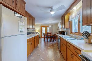 a kitchen with wooden cabinets and a white refrigerator at Serene Cape Escape in Wellfleet +22 photos