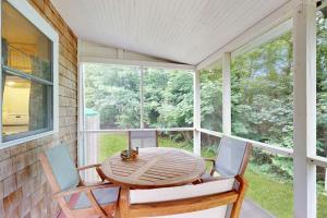 a porch with a wooden table and two chairs at Seabreeze Retreat in Oak Bluffs