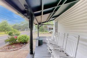 a porch with white chairs on a house at Seabreeze Retreat in Oak Bluffs
