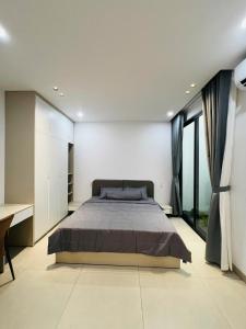 a bedroom with a large bed and large windows at Homestay Ninh Chữ in Thanh Hải
