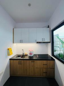 a small kitchen with white cabinets and a sink at Homestay Ninh Chữ in Thanh Hải