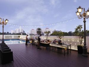 a rooftop deck with a pool and people standing on it at Grand Mercure Vadodara Surya Palace in Vadodara