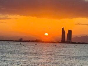 a sunset over a body of water with a city at Homestay Ninh Chữ in Thanh Hải